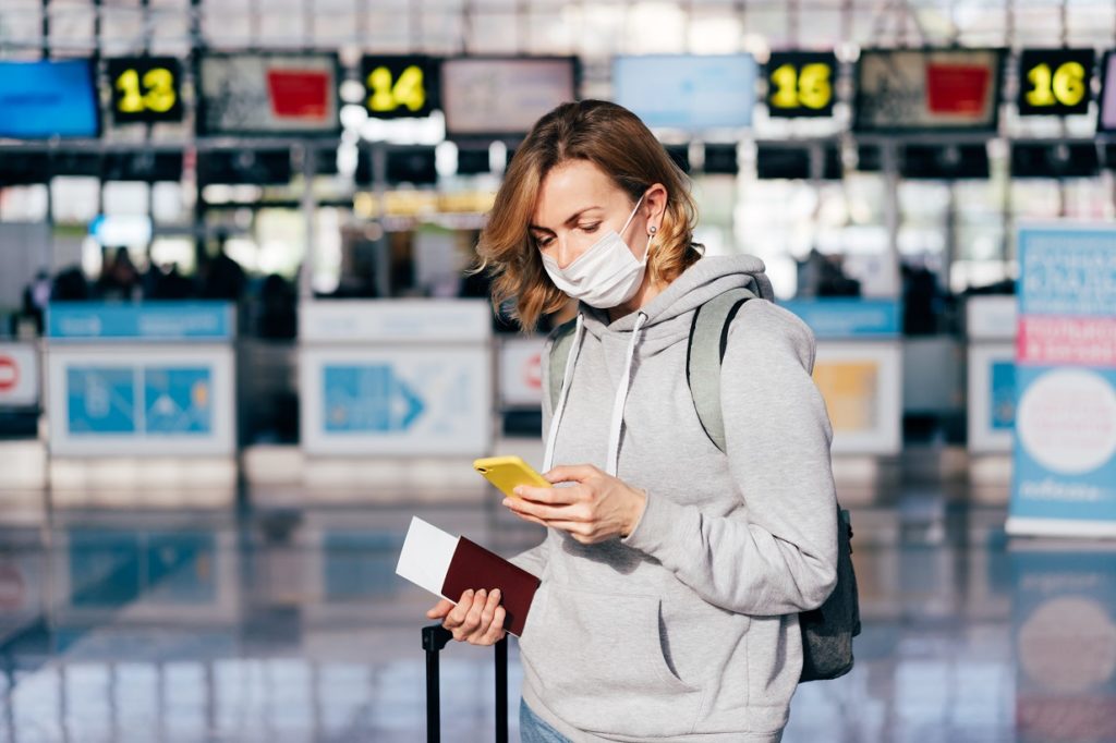 a young woman in a medical protective mask stands 463TKKN